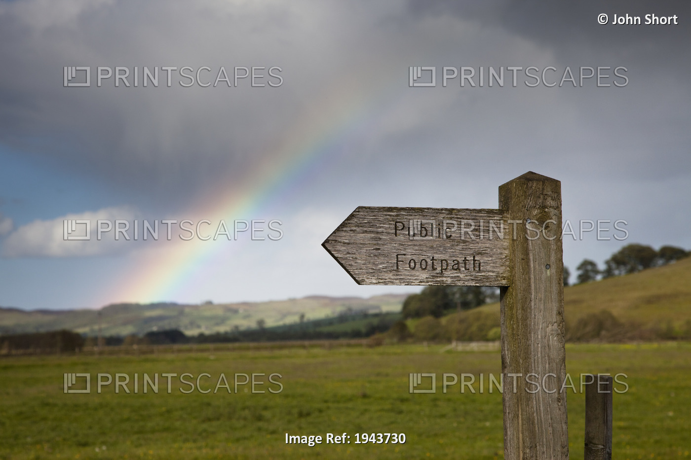 A Wooden Sign For A Public Footpath With A Rainbow In The Background; ...
