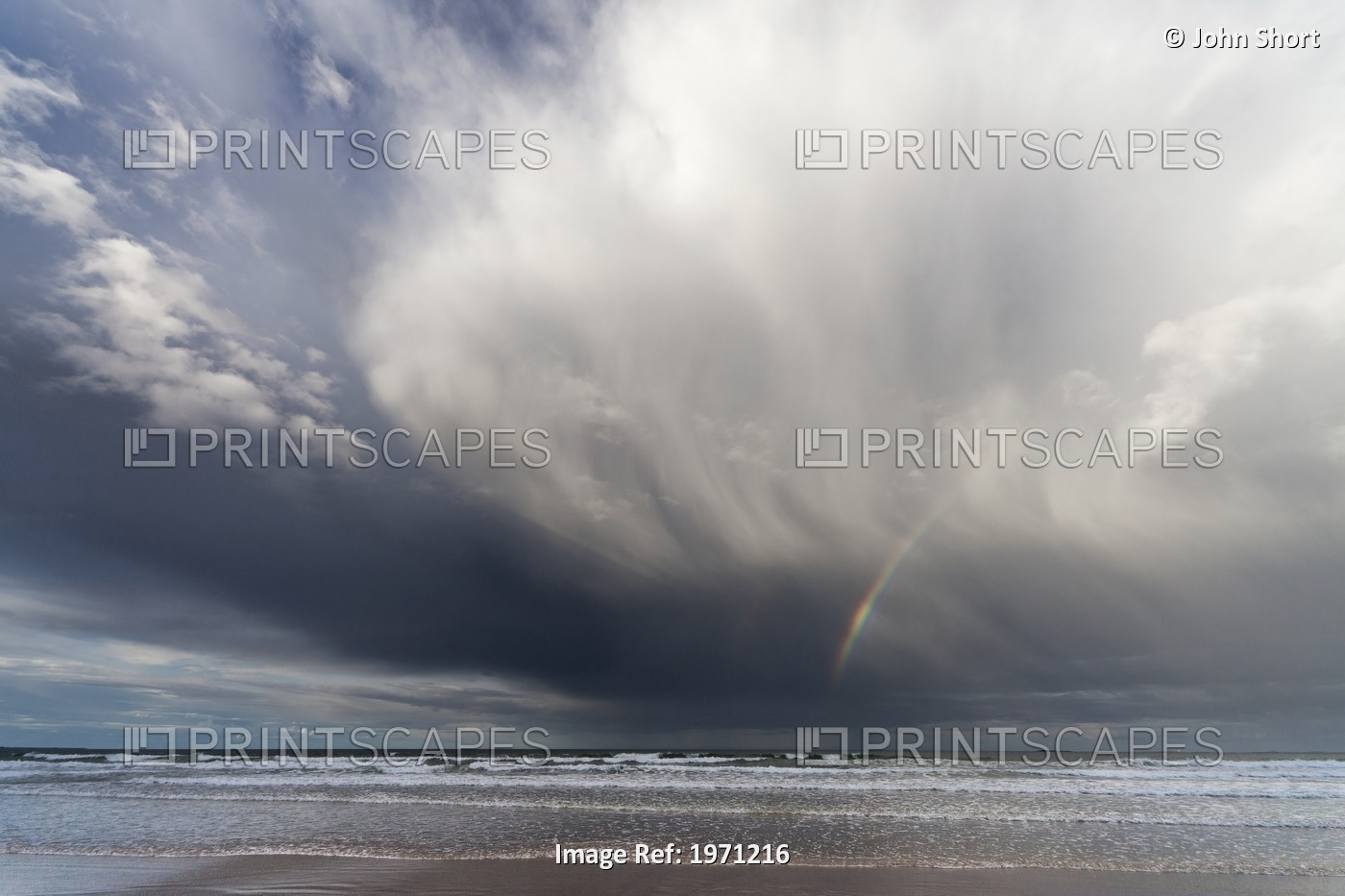 A Rainbow In The Dark Clouds Over The Ocean; Bamburgh, England