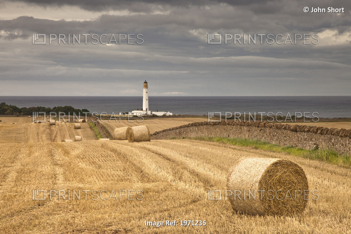 Barns Ness Lighthouse Along The Coast And Hay Bales In A Field In The ...