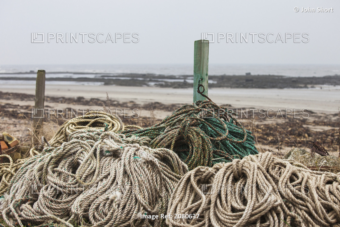 Piles Of Various Ropes And Wooden Posts At The Water's Edge; Boulmer, ...