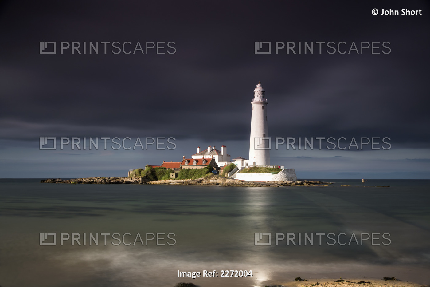 White Lighthouse Illuminated By Sunlight Under A Dark Stormy Sky; St. Mary's ...