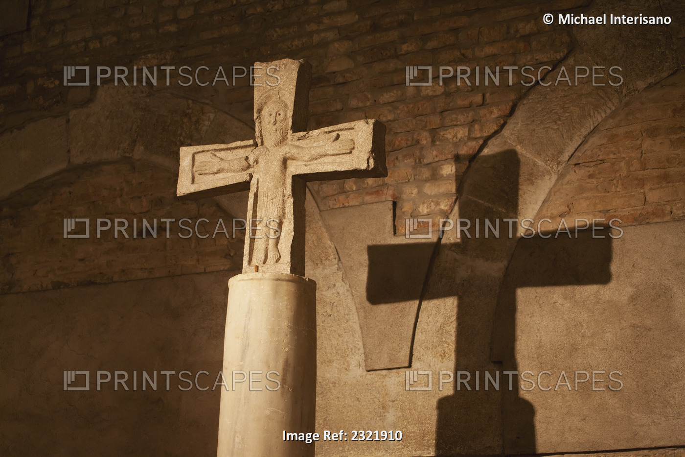 Close up of stone cross/crucifix with a shadow on brick wall in ...