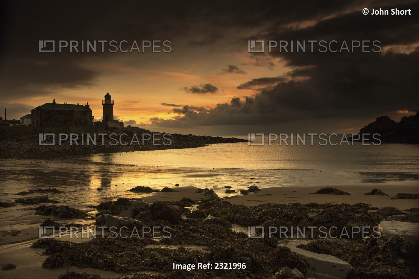 Silhouette of a lighthouse along the coast at sunset;Portpatrick dumfries and ...