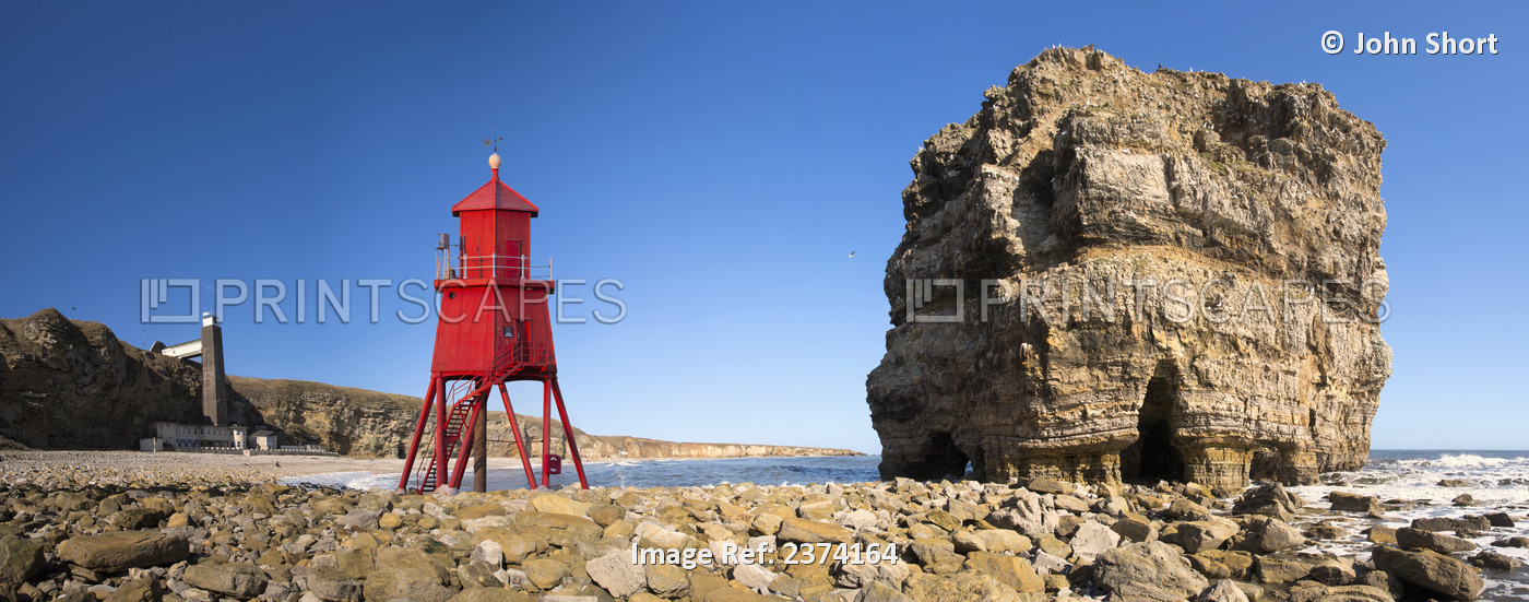 Groyne Lighthouse Beside A Rock Formation Along The Shoreline; South Shields, ...