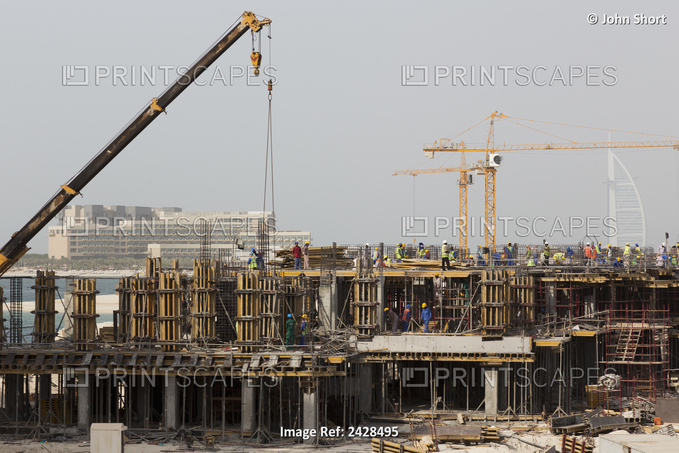 Cranes At A Building Site With Numerous Workers Working On The Building; Dubai, ...
