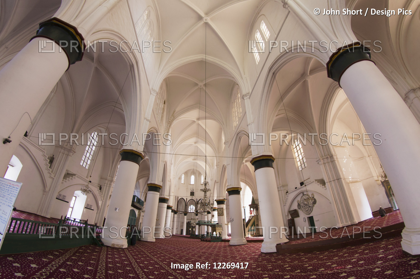 Interior Of A Building With Large White Columns, Archways And Red Carpet; ...