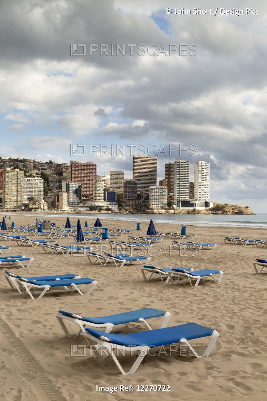 Blue Lounge Chairs On The Beach Along The Mediterranean; Benidorm, Spain