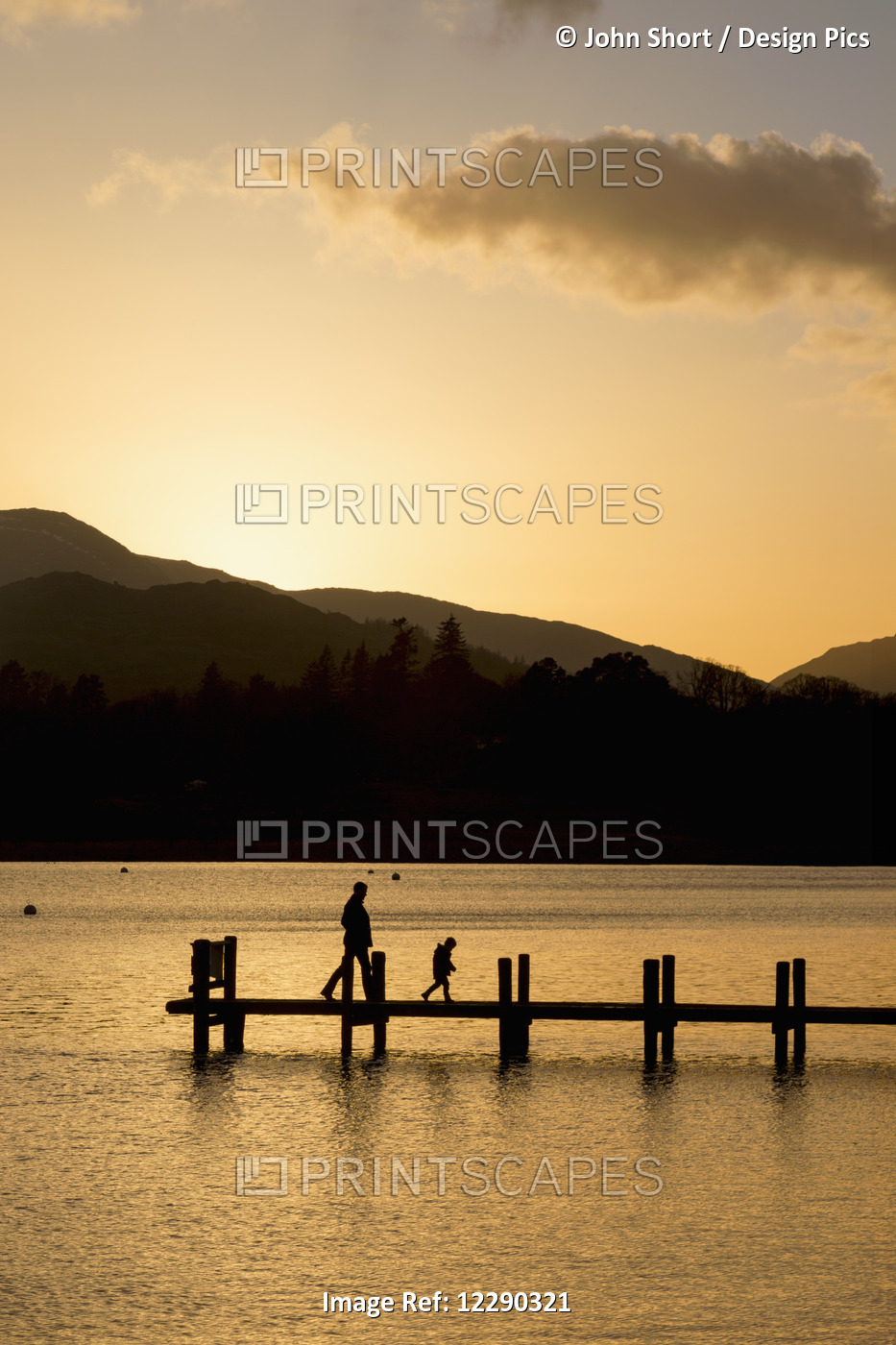 Silhouette Of A Parent And Child Walking On A Dock On A Tranquil Lake At ...
