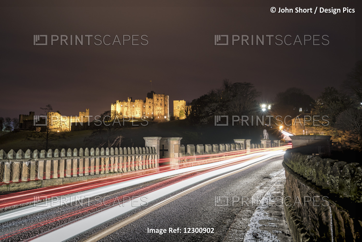 Light Trails On A Road And Illuminated Building In The Background At Nighttime; ...