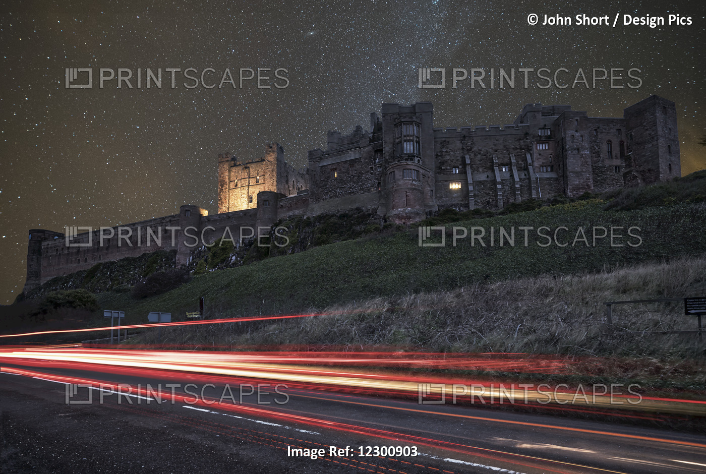Light Trails On A Road And A Star Filled Sky Over Bamburgh Castle At Nighttime; ...