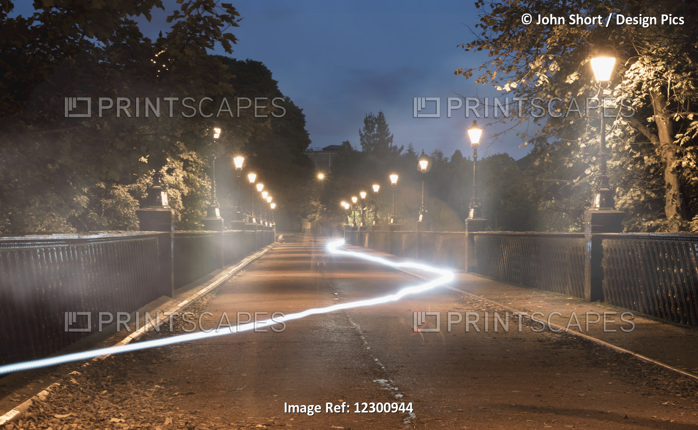 Light Trail Glowing In A Path Lit By Lamp Posts At Dusk; Newcastle, Tyne And ...