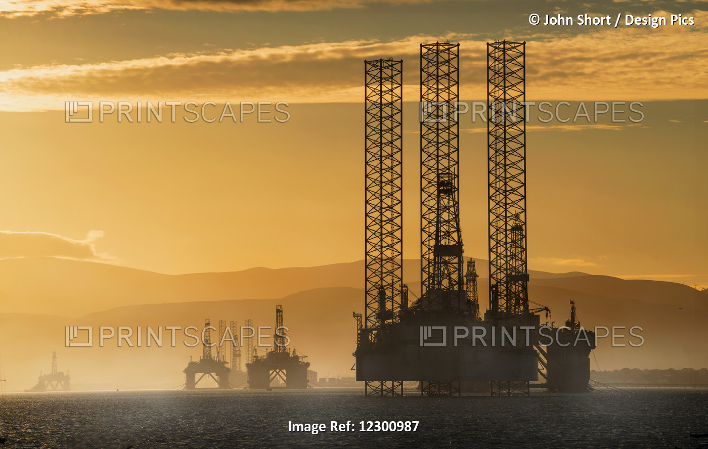 Oil Drilling Rigs Out In The Ocean With A View Of The Coastline And Golden ...
