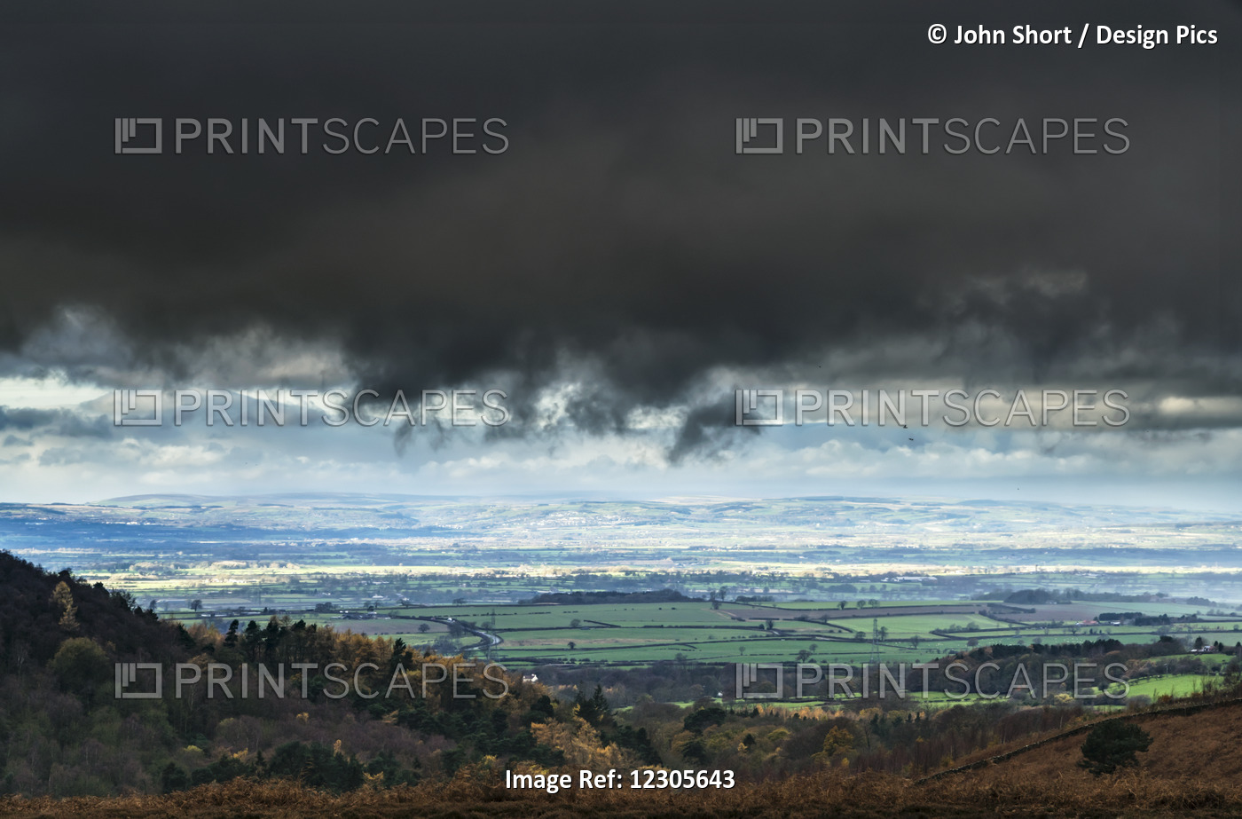 Dark Storm Clouds Over A Landscape Of Green Farmland; Yorkshire, England