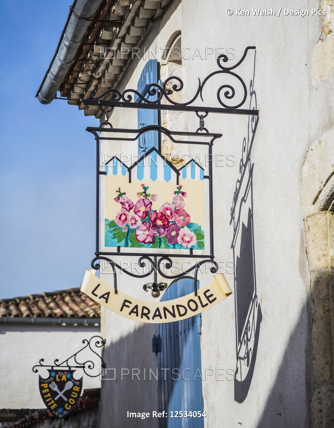 Colourful sign for La Farandole restaurant hanging from a wall; ...