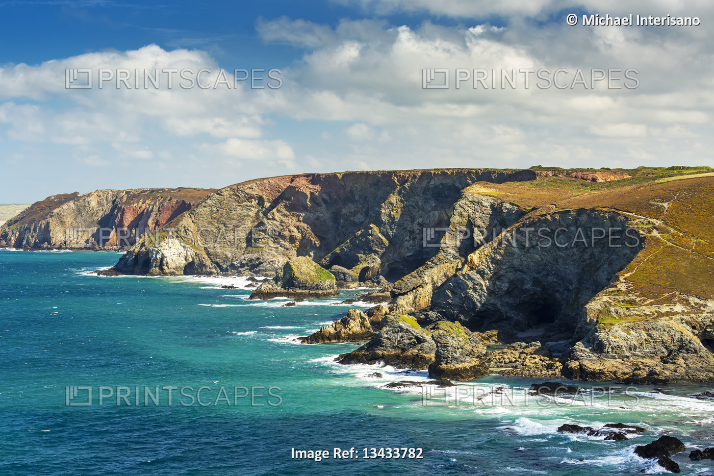 Rocky cliffs along the shoreline with clouds and blue sky; Cornwall County, ...